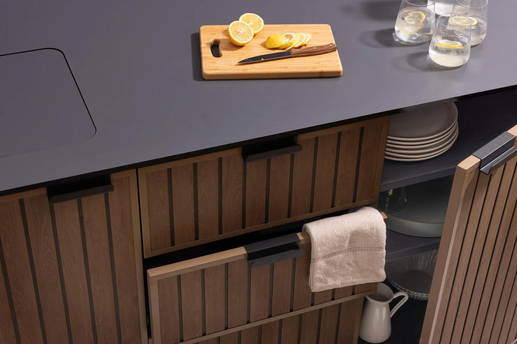 Detalle de los cajones y la cubierta de la cocina exterior Keter en uso