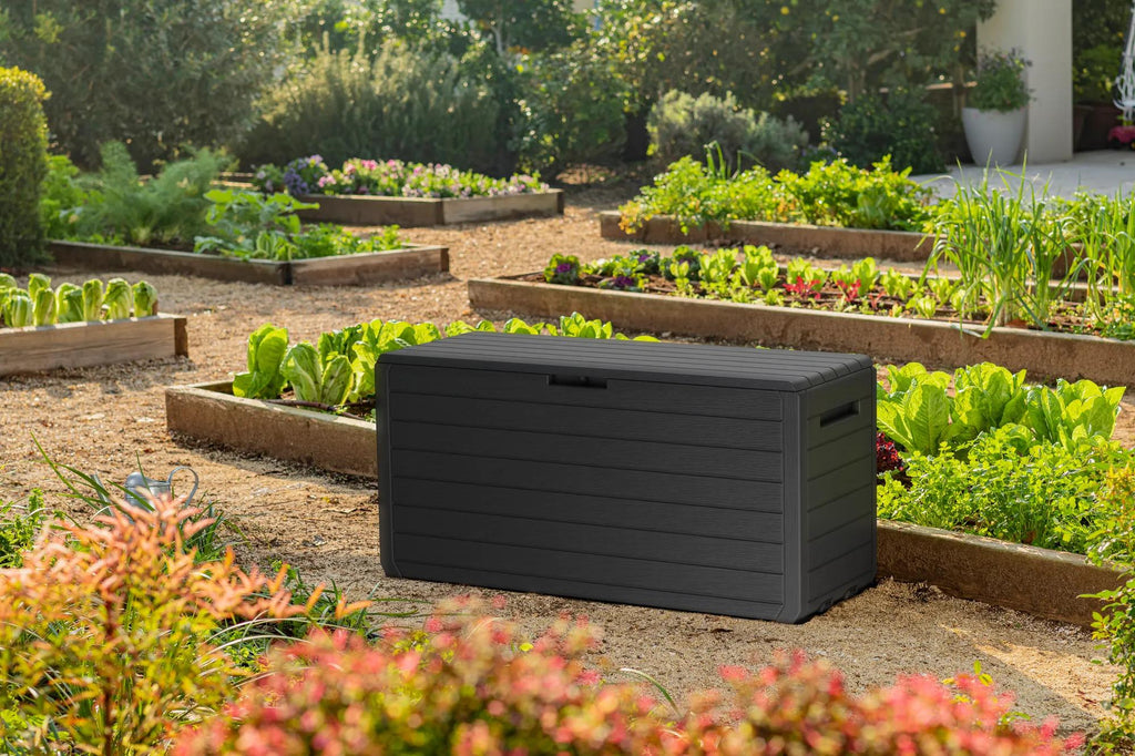 Baul Keter Atlas cerrado en un jardin junto a jardineras